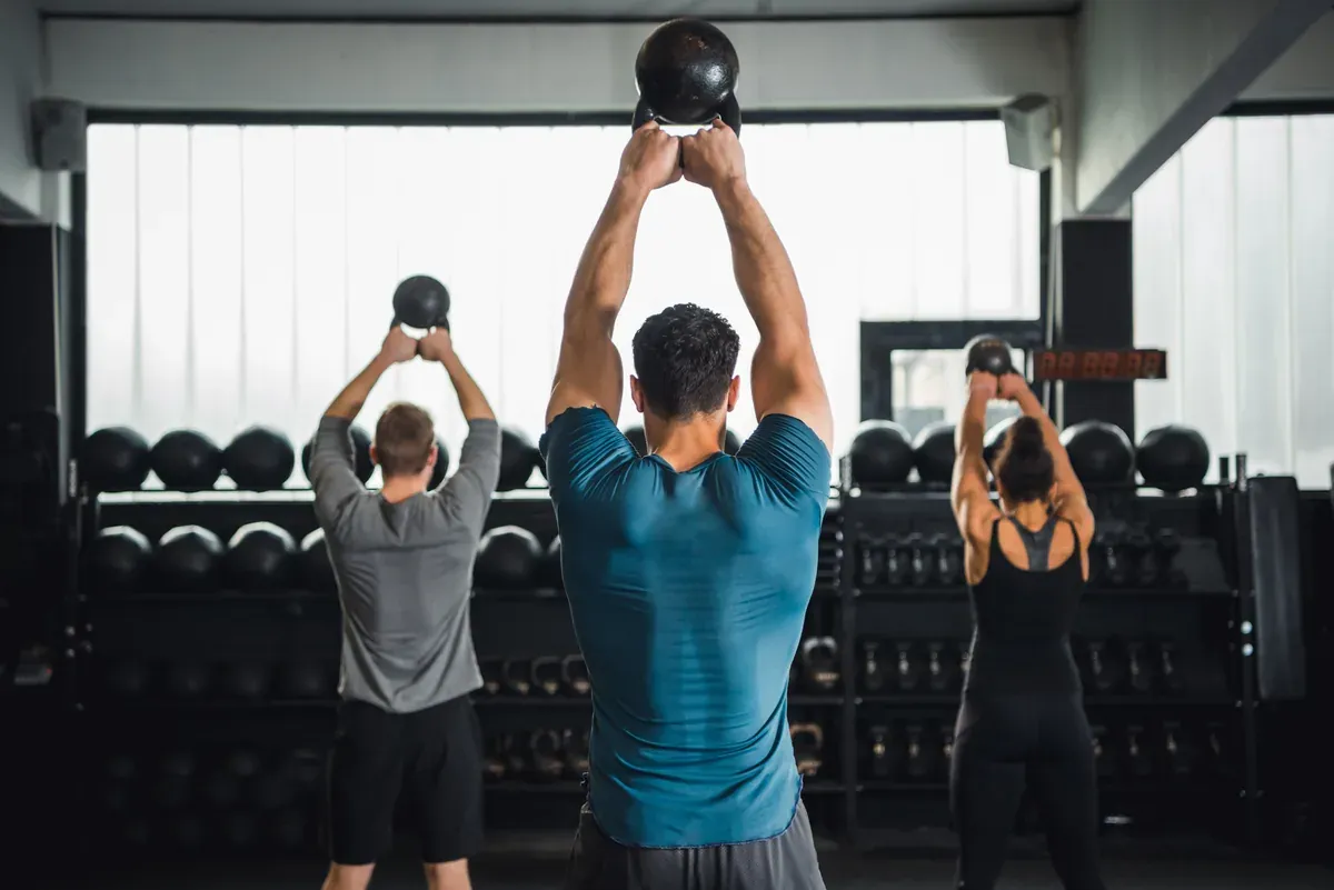 Athletes training with kettlebells in a gym