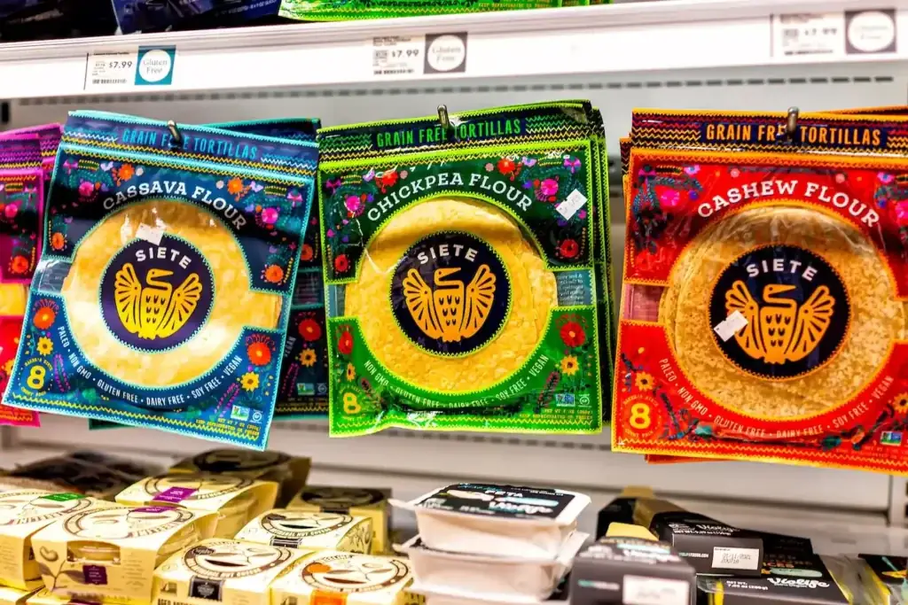 Siete Family Foods tortillas hang on shelf in grocery store.