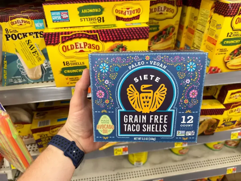 Person holding Siete taco shells inside of grocery store.