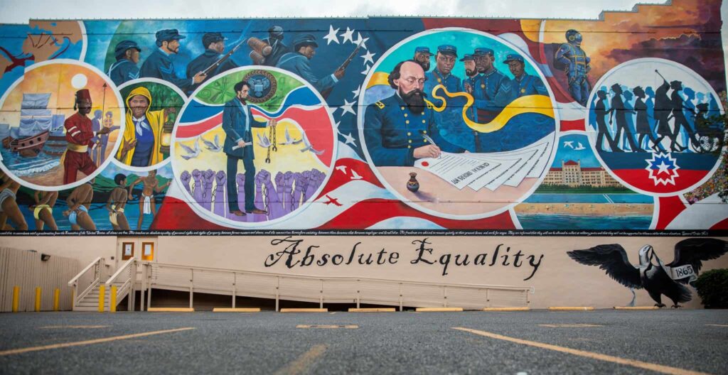 A large mural illustrating the history of Juneteenth with the words Absolute Equality painted underneath